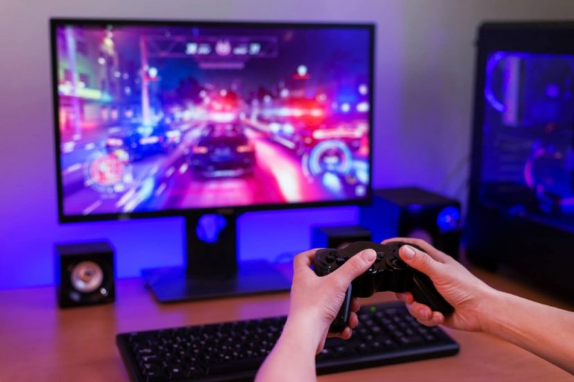 playing-racing-games-computer-concept-hand-holds-joystick-background-is-gaming-computer-with-rgb-light (2) (1)